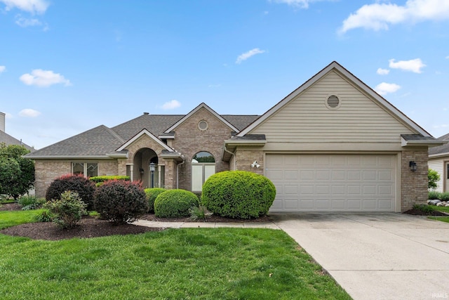 traditional home with brick siding, an attached garage, driveway, and a front yard