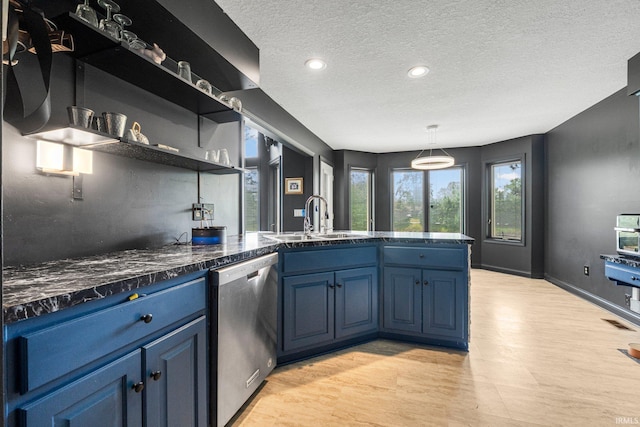kitchen with stainless steel dishwasher, a sink, blue cabinetry, light wood finished floors, and a peninsula