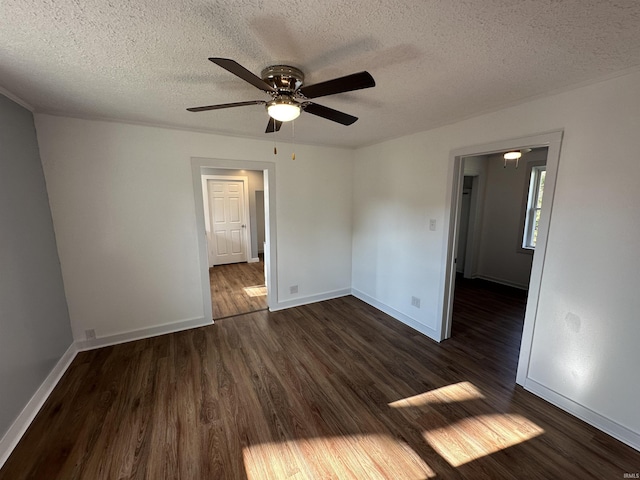 807 Walnut St, Oolitic, IN 47451 - spare room with dark wood-type flooring, a ceiling fan, a textured ceiling, and baseboards