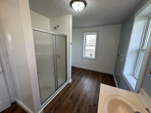 807 Walnut St, Oolitic, IN 47451 - bathroom with a stall shower, a textured ceiling, wood finished floors, baseboards, and vanity