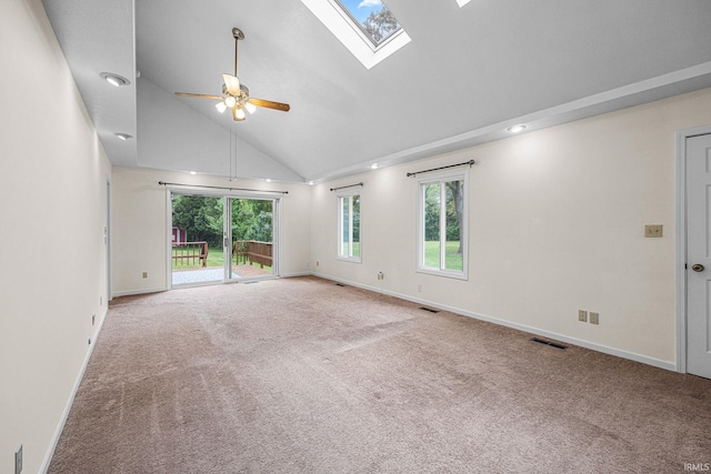 carpeted empty room with ceiling fan, a skylight, high vaulted ceiling, and baseboards