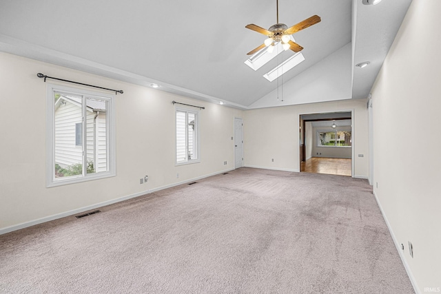 empty room with ceiling fan, a skylight, carpet flooring, baseboards, and recessed lighting