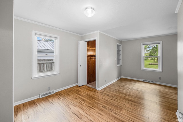 unfurnished bedroom featuring wood finished floors, ornamental molding, and baseboards