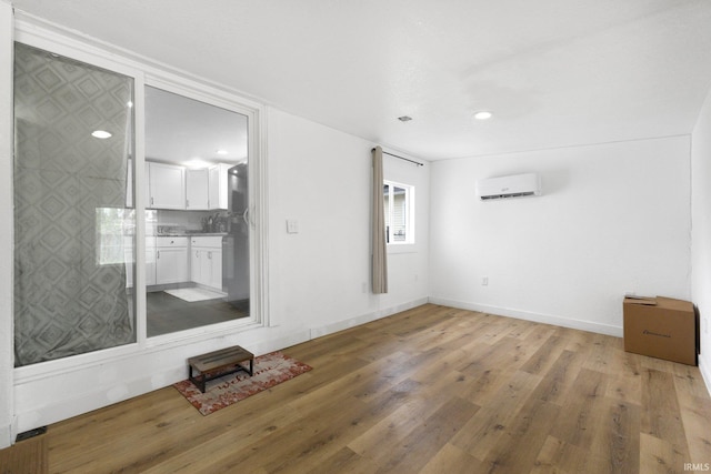 414 Monroe St, Monroeville, IN 46773 - empty room featuring a wall mounted air conditioner, light wood-style flooring, baseboards, and recessed lighting