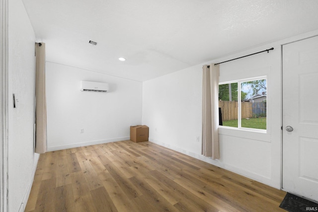 414 Monroe St, Monroeville, IN 46773 - empty room with a wall unit AC, light wood-type flooring, recessed lighting, and baseboards