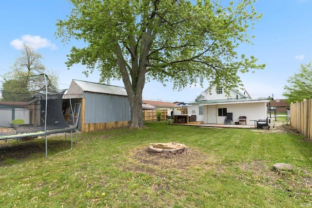 414 Monroe St, Monroeville, IN 46773 - view of yard with a trampoline, an outdoor fire pit, an outbuilding, a storage shed, and a deck