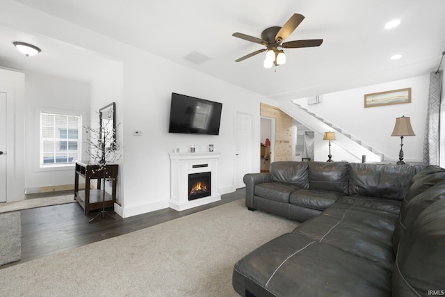 414 Monroe St, Monroeville, IN 46773 - living area featuring stairway, dark wood-type flooring, recessed lighting, ceiling fan, and a warm lit fireplace