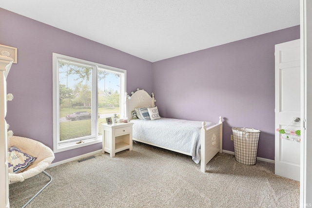 bedroom with light colored carpet and baseboards