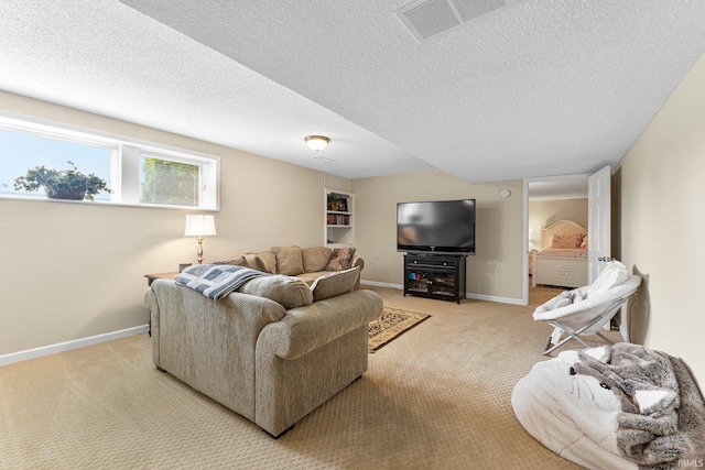living area with light carpet, a textured ceiling, and baseboards