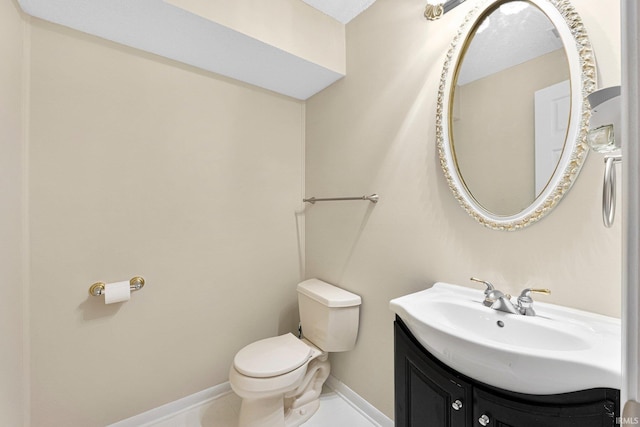 bathroom featuring toilet, baseboards, vanity, and tile patterned flooring