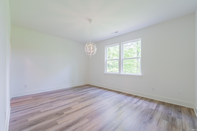 1846 E Cumberland Ter, Martinsville, IN 46151 - spare room with baseboards, light wood-style flooring, and a chandelier