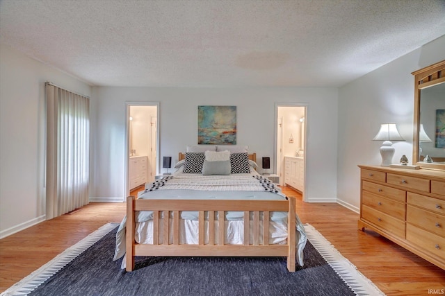 bedroom with light wood-style floors, ensuite bathroom, baseboards, and a textured ceiling