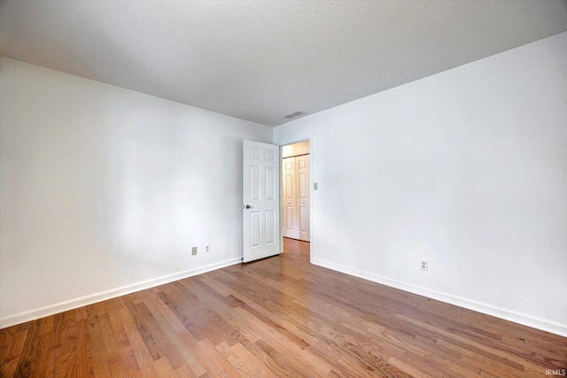 unfurnished room featuring wood finished floors and baseboards