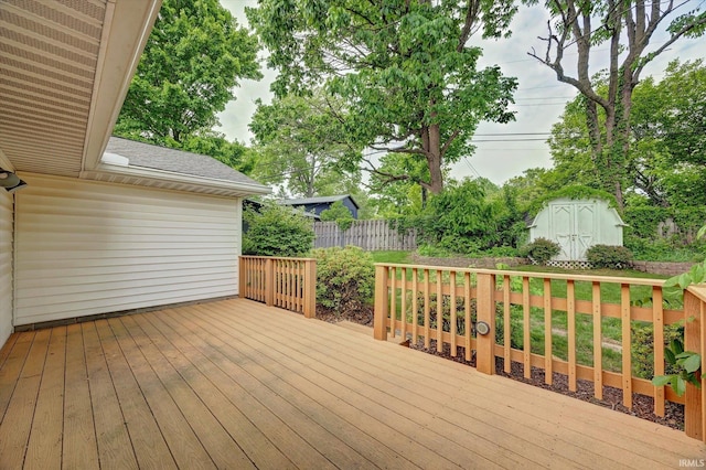 wooden terrace featuring a storage shed, an outdoor structure, and fence