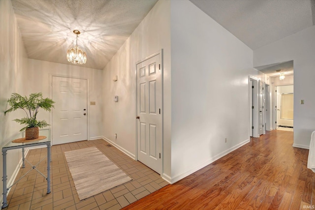 entryway with a chandelier, vaulted ceiling, and baseboards
