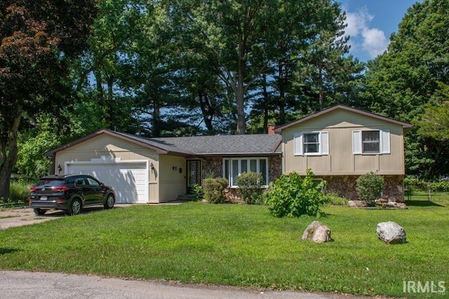 tri-level home featuring a garage, a front lawn, stone siding, and concrete driveway