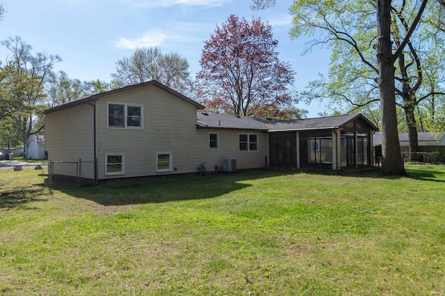 rear view of house with a sunroom, a chimney, and central AC unit