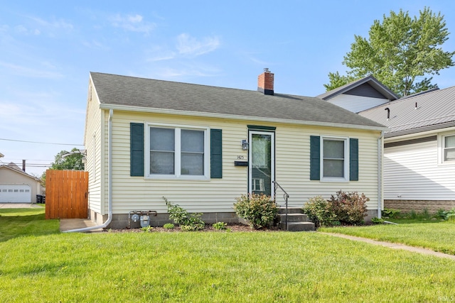 1425 Adams St, Lafayette, IN 47905 - view of front of home with a chimney, a front lawn, and a shingled roof