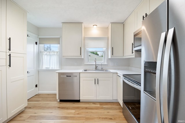 1425 Adams St, Lafayette, IN 47905 - kitchen with appliances with stainless steel finishes, a sink, light wood-style flooring, light countertops, and healthy amount of natural light