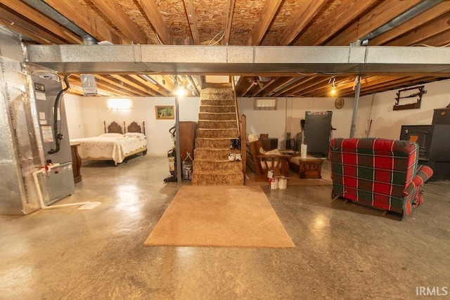 unfinished basement featuring stairs and heating unit