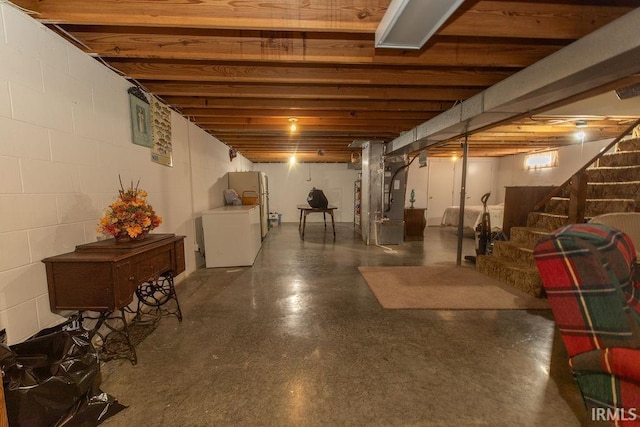 finished basement featuring washer / dryer, stairway, and heating unit