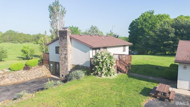 view of property exterior featuring a yard, a chimney, a deck, and stairs