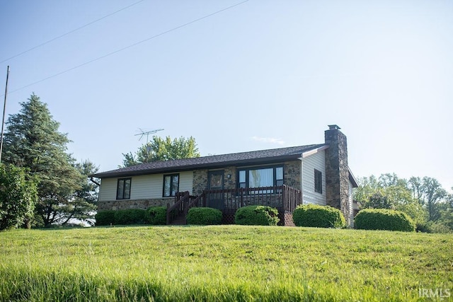 ranch-style house with stone siding, a chimney, a front lawn, and a deck