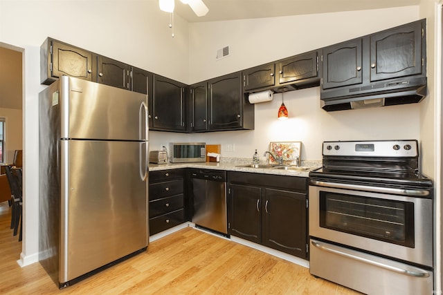kitchen with stainless steel appliances, a sink, under cabinet range hood, light wood-style floors, and ceiling fan