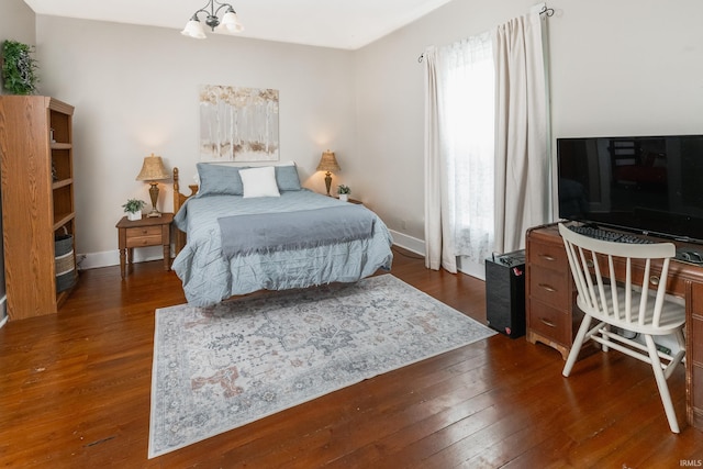 bedroom with dark wood-style floors and baseboards