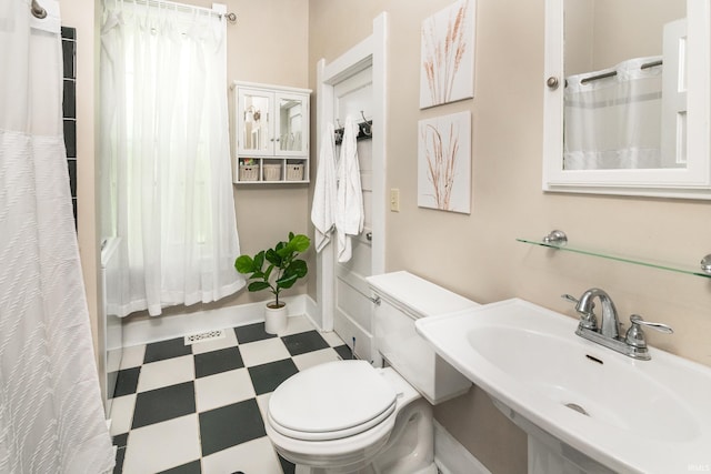 full bathroom with tile patterned floors, a sink, toilet, and shower / bathtub combination with curtain