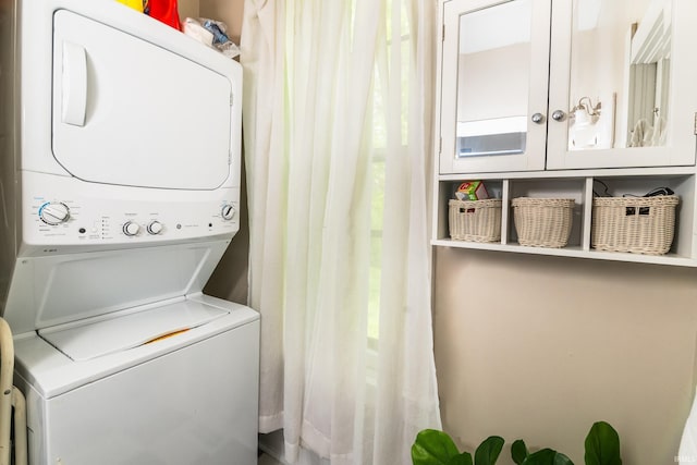 clothes washing area with stacked washer / dryer