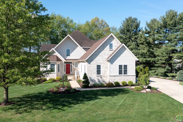 craftsman-style house featuring stone siding, a front lawn, and roof with shingles