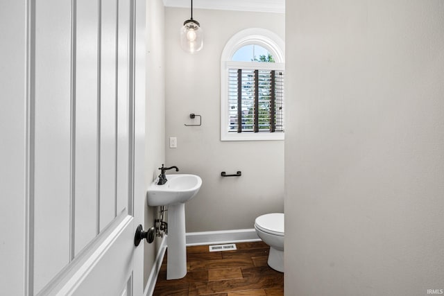 bathroom with baseboards, toilet, and wood finished floors