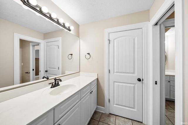 bathroom featuring vanity, a textured ceiling, and baseboards
