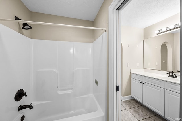 full bath with a textured ceiling, shower / tub combination, tile patterned flooring, and vanity