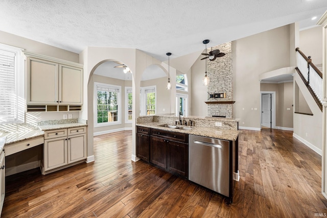 kitchen featuring dishwasher, a sink, ceiling fan, arched walkways, and hardwood / wood-style flooring