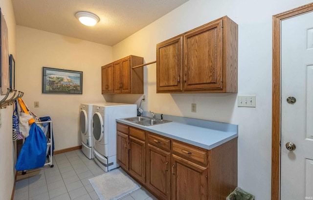 clothes washing area featuring cabinet space, washing machine and clothes dryer, light tile patterned floors, and baseboards