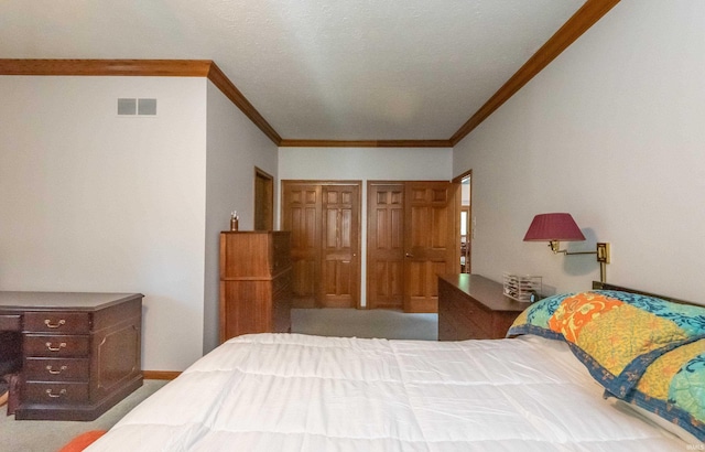 carpeted bedroom featuring ornamental molding and multiple closets