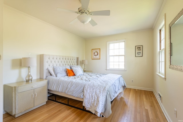 bedroom featuring light wood-type flooring, multiple windows, baseboards, crown molding, and a ceiling fan