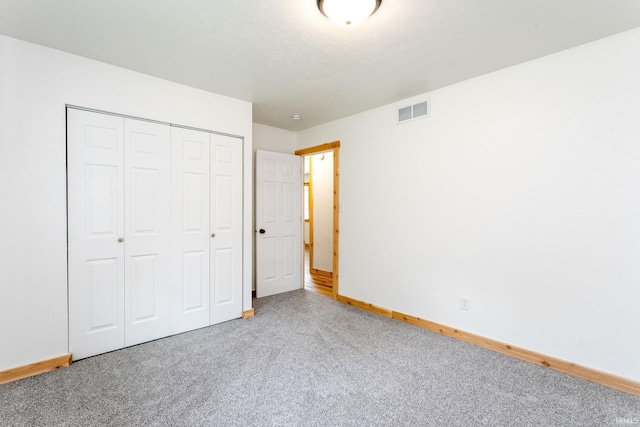 unfurnished bedroom with carpet flooring, a closet, and baseboards