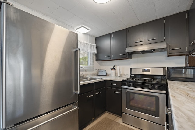 47 Ems W29B Ln, North Webster, IN 46555 - kitchen with stainless steel appliances, under cabinet range hood, a sink, light countertops, and dark cabinetry