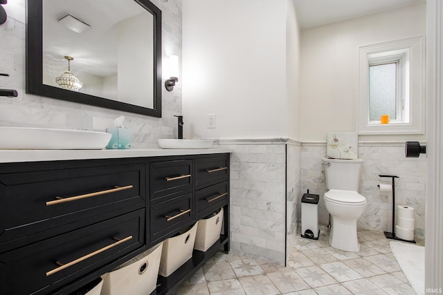 4 Edgewater Pl, Elkhart, IN 46516 - bathroom with tile walls, toilet, double vanity, and a wainscoted wall