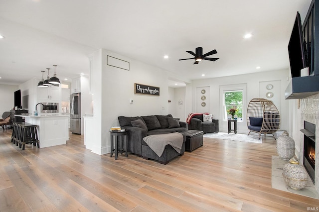 4 Edgewater Pl, Elkhart, IN 46516 - living room with a lit fireplace, a ceiling fan, light wood-style flooring, and recessed lighting