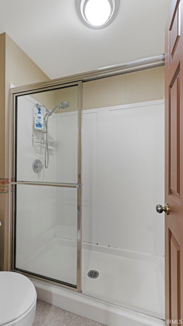 full bath featuring a stall shower and toilet