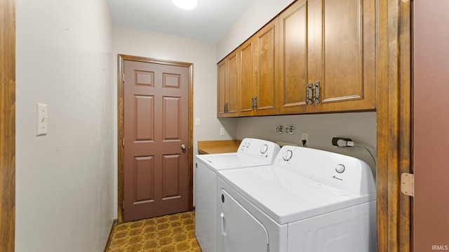laundry area with cabinet space, washing machine and dryer, and dark floors