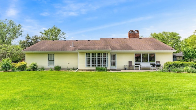 back of house with a patio, a yard, and a chimney