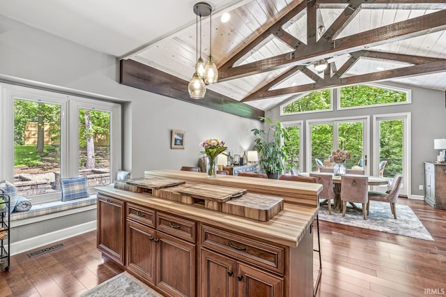 kitchen featuring butcher block counters, dark wood-style floors, hanging light fixtures, wooden ceiling, and brown cabinetry