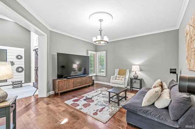 living area featuring crown molding, wood finished floors, a chandelier, and baseboards