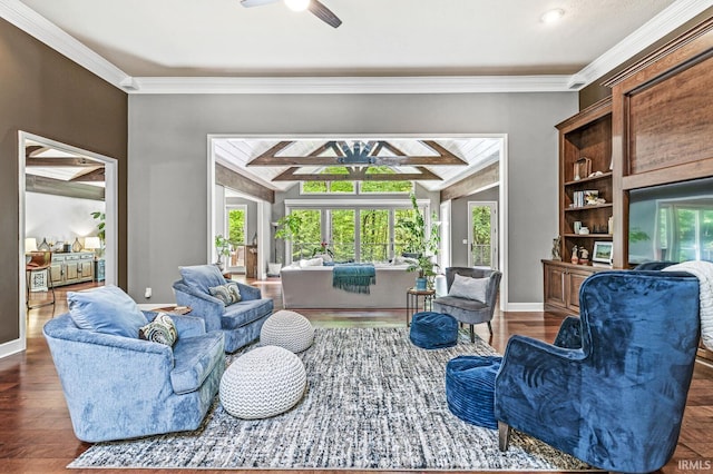 living room featuring ceiling fan, healthy amount of natural light, vaulted ceiling, crown molding, and wood finished floors