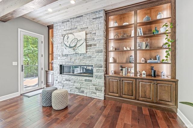living area with dark wood-style floors, baseboards, a stone fireplace, wooden ceiling, and recessed lighting
